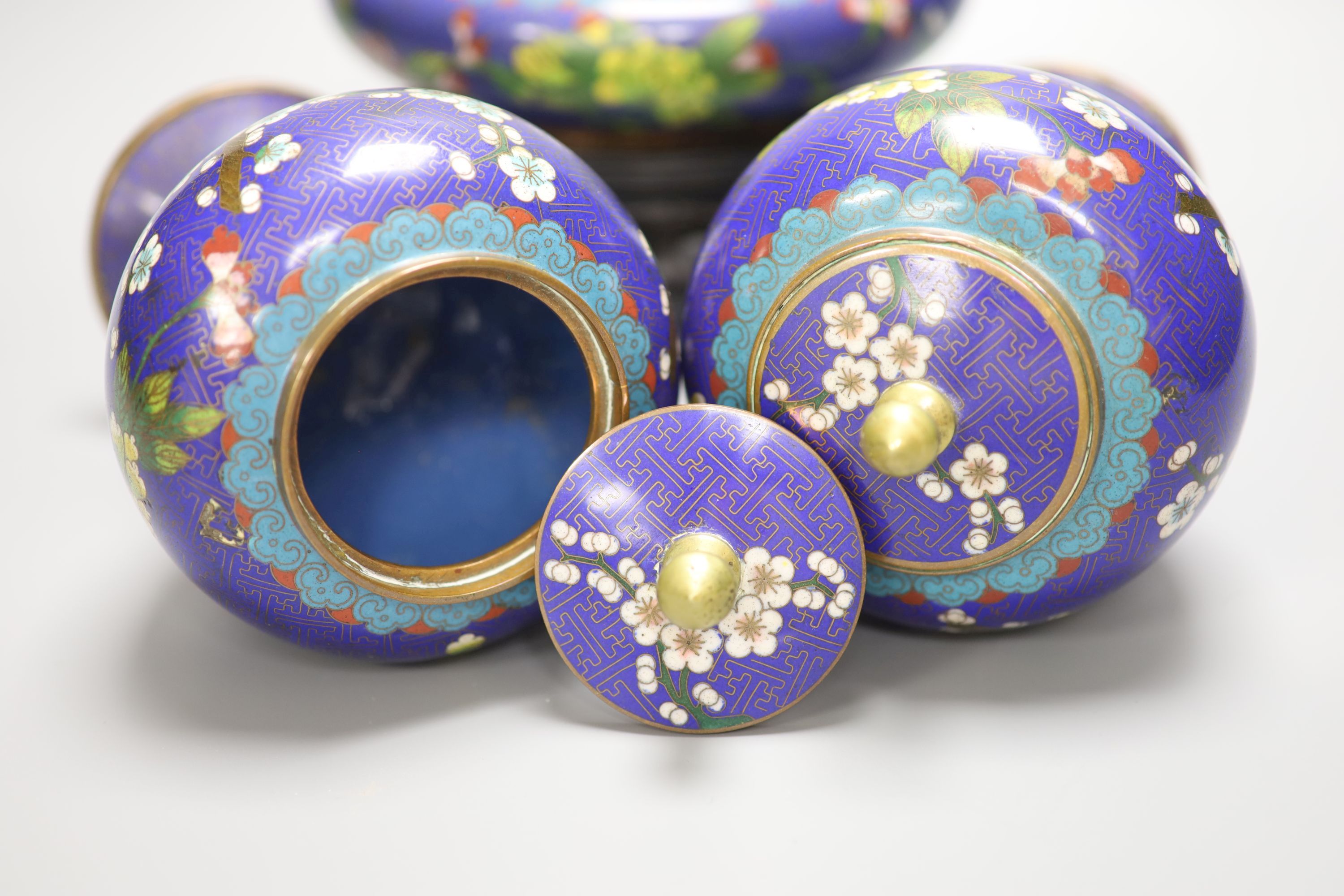 A pair of early 20th century Chinese cloisonne enamel jars and covers and a similar bowl and wood stand, tallest 20cm